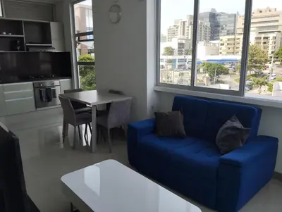 a living room with a blue couch and a table at Apartaestudio Jacuzzi Centro Comercial Gimnasio ALTOPRADO in Barranquilla