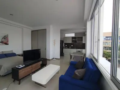 a living room with a blue couch and a tv at Apartaestudio Jacuzzi Centro Comercial Gimnasio ALTOPRADO in Barranquilla