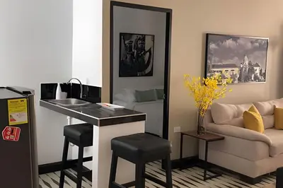 a kitchen with a counter and a living room with a couch at Céntrico y confortable apto Casa Doña Yola 11 in Cartagena de Indias