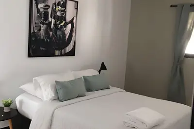 a bedroom with a bed with white sheets and blue pillows at Céntrico y confortable apto Casa Doña Yola 11 in Cartagena de Indias