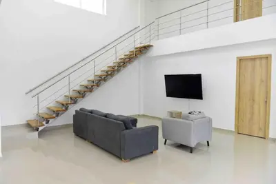 a living room with a couch and a tv and a staircase at Espectacular casa en oferta con piscina privada y vista al mar in Carretal