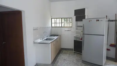 a white kitchen with a sink and a refrigerator at Cabaña La Pereztroica 2 in Puerto Viejo