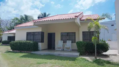 two white chairs sitting outside of a house at Cabaña La Pereztroica 2 in Puerto Viejo