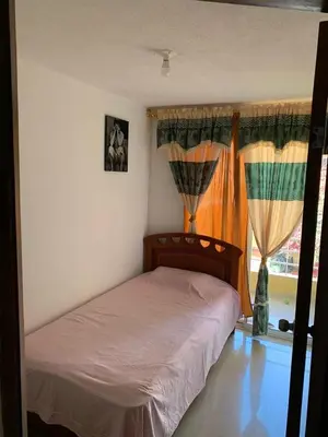 a bedroom with a bed and a window with curtains at Habitación Estrella de Mar in Barranquilla