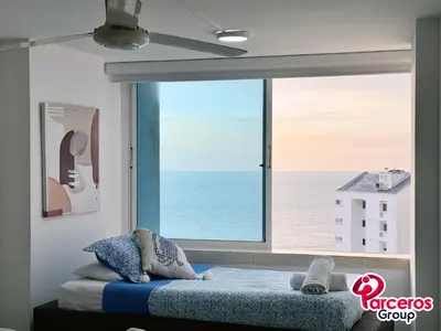 a bedroom with a large window with a view of the ocean at Amplio Apartamento Para Grupos Cerca Al Mar Por Parceros Group in Cartagena de Indias