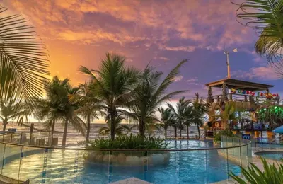 a pool at a resort with palm trees and a ride at SUITE OCEAN VIEW - Playa in Tolú