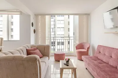 a living room with pink furniture and a large window at Loft en Nrt de Barranquilla - Piscina - Mall 3 Min in Barranquilla