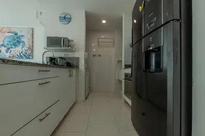 a kitchen with a black refrigerator and white cabinets at Edificio Morros 3 in Cartagena de Indias