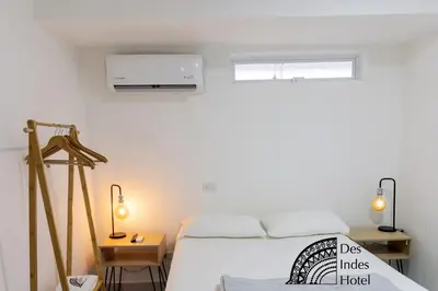 a white bedroom with a bed and a window at DES INDES CARTAGENA in Cartagena de Indias