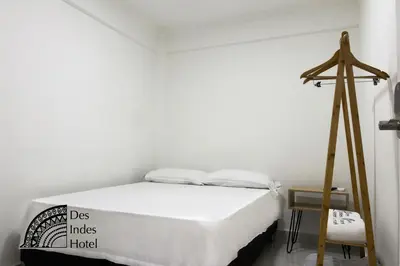 a white bedroom with a bed and a tripod at DES INDES CARTAGENA in Cartagena de Indias