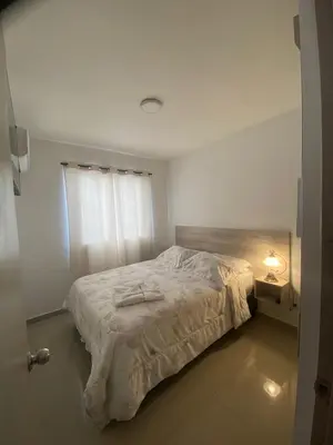 a bedroom with a bed with a white comforter at Apartamento Cerca Playa Marbella in Cartagena de Indias