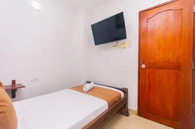 a small bedroom with a bed and a flat screen tv at Hotel Med Cartagena in Cartagena de Indias