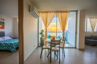 a room with a table and chairs and a bedroom at Exclusivo apartamento en Cielo Mar-playa las Americas, con maravillosas vistas del atardecer de Cartagena in Cartagena de Indias