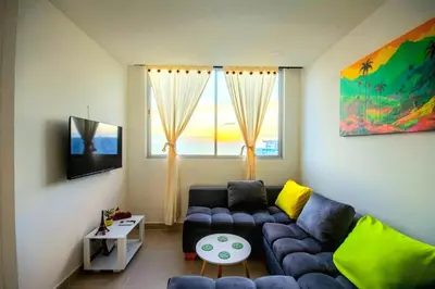 a living room with a blue couch and a window at Exclusivo apartamento en Cielo Mar-playa las Americas, con maravillosas vistas del atardecer de Cartagena in Cartagena de Indias