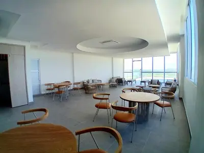 an empty room with tables and chairs and windows at Exclusivo apartamento en Cielo Mar-playa las Americas, con maravillosas vistas del atardecer de Cartagena in Cartagena de Indias