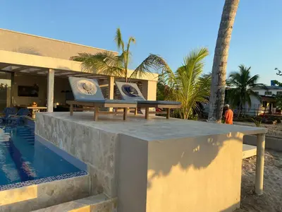 a table next to a swimming pool next to a building at Cabañas Privadas en Playas del Francés con Piscina in San Silvestre
