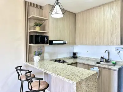 a kitchen with a sink and a counter with two chairs at Moderno e Iluminado Apartamento in Sincelejo