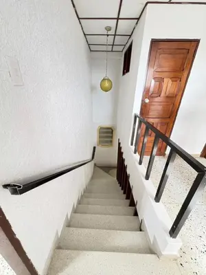a staircase in a building with a wooden door at Casa Ciudad Jardin Centro Histórico in Barranquilla