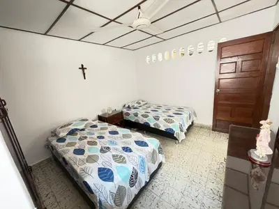 two beds in a room with a cross on the ceiling at Casa Ciudad Jardin Centro Histórico in Barranquilla