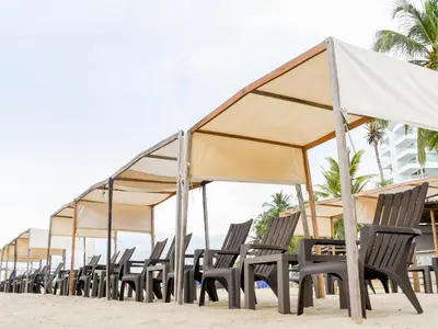 a row of chairs and umbrellas on a beach at Ciela Hotel in Coveñas