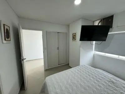 a bedroom with a bed and a flat screen tv at Apartamento en Edificio Portofino 606 ICDI in Cartagena de Indias