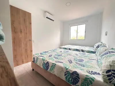 a bedroom with two beds and a window at Casa 5 Brisa Piso 2- Palmar De Los Vientos in San Bernardo del Viento
