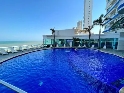 a large blue swimming pool next to a beach at Apartamento ideal frente al mar con vista espectacular in Cartagena de Indias