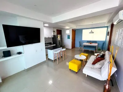 a living room with a white couch and a kitchen at Apartamento ideal frente al mar con vista espectacular in Cartagena de Indias