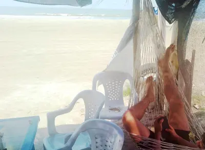a person laying in a hammock on the beach at Casa MAR de FE in Cartagena de Indias