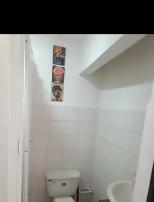 a bathroom with a toilet and two pictures on the wall at Hermoso apartamento in Cartagena de Indias