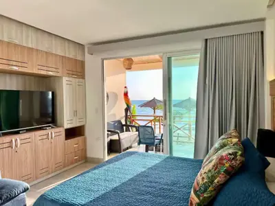 a bedroom with a bed and a tv and a balcony at Casa Luna Laguna Beach in Tolú