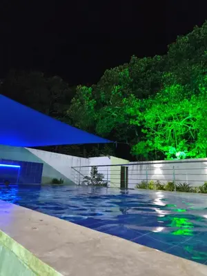 a swimming pool at night with blue and green lights at Hotel Palmetto Beach Coveñas in Coveñas