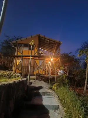 a tree house at night with a pathway leading to it at Puerta al Mar Ecolodge Glamping in Tubará