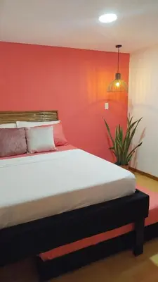 a bedroom with a bed with a red wall at Hb7 Quadruple Room with shared bathroom in Cartagena de Indias