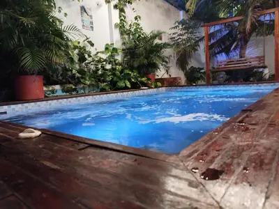 a swimming pool in a house with blue water at Hb7 Quadruple Room with shared bathroom in Cartagena de Indias