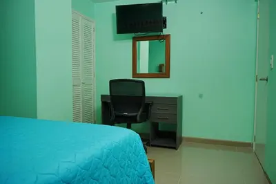 a bedroom with a bed and a desk and a mirror at Frente al mar, Boca grande APT1105 in Cartagena de Indias