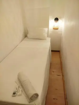 a small bedroom with a white bed with a towel on it at Beach House In La Boquilla Facing the Sea With Air Conditioning and WIFI in Cartagena de Indias