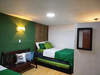 a small room with a bed with green walls at Beach House In La Boquilla Facing the Sea With Air Conditioning and WIFI in Cartagena de Indias
