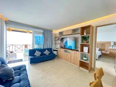 a living room with a blue couch and a tv at Hermosa Suite frente al mar en Tolu-Sucre in San Silvestre