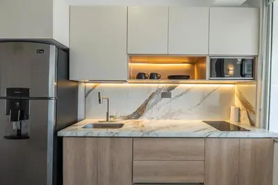 a kitchen with white cabinets and a marble counter top at Panoramic Oceanview Loft Near Beach & Airport in Cartagena de Indias