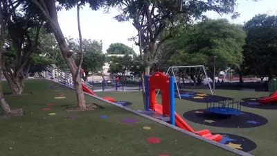 a park with a playground with a slide and swings at B&B Grand Royal Inn in Barranquilla