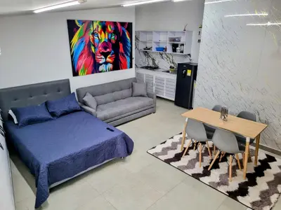 a bedroom with a bed and a table and a couch at Apartamento Cerca al Faro y la Playa in Puerto Colombia