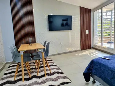 a room with a table and chairs and a tv at Apartamento Cerca al Faro y la Playa in Puerto Colombia