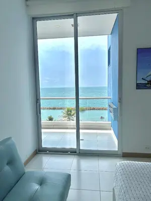 a room with a large sliding glass door with a view of the ocean at Apartamento con vista al mar en Coveñas in Coveñas