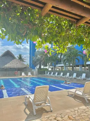 a swimming pool with two chairs and a table at Apartamento con vista al mar en Coveñas in Coveñas