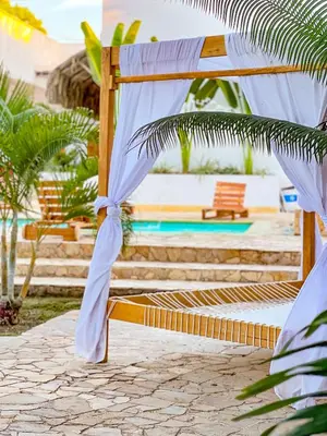 a hammock on a beach next to a pool at Hotel Palma Grande by Stanza in Coveñas