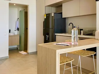 a kitchen with a counter with chairs and a refrigerator at Wynwood Cartagena Beach in Cartagena de Indias