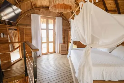a bedroom with a bed in a wooden house at JERUSALEMA BEACH GLAMPING in Tolú