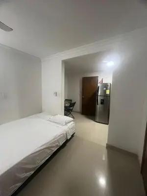 a room with a bed and a refrigerator in it at A un paso del mar in Cartagena de Indias