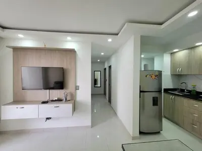 a kitchen with a refrigerator and a tv on the wall at Apartamento cerca al Mar, en Cartagena COL in Cartagena de Indias